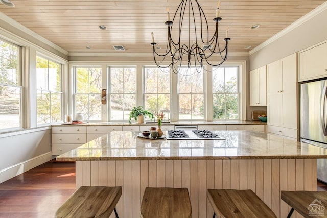 kitchen with light stone countertops, appliances with stainless steel finishes, and plenty of natural light