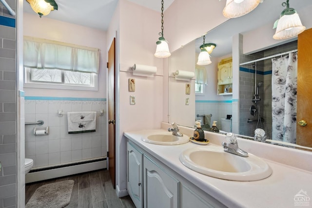 bathroom featuring a sink, tile walls, toilet, and baseboard heating