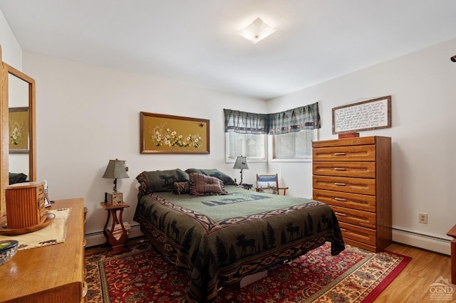 bedroom with a baseboard radiator, baseboards, and wood finished floors