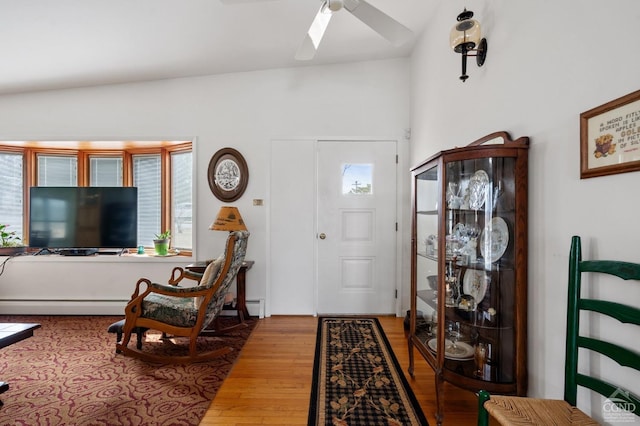 foyer with a skylight, wood finished floors, a ceiling fan, and a baseboard radiator