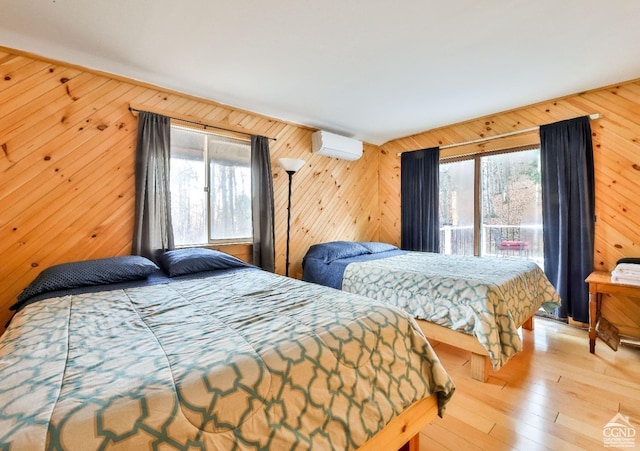 bedroom with light wood-type flooring, multiple windows, and wood walls