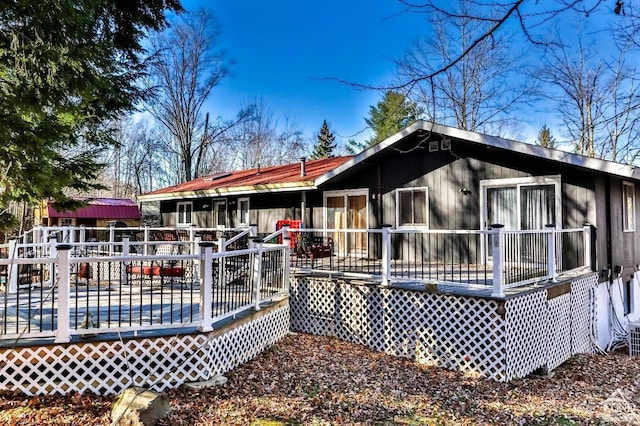 rear view of house featuring a wooden deck