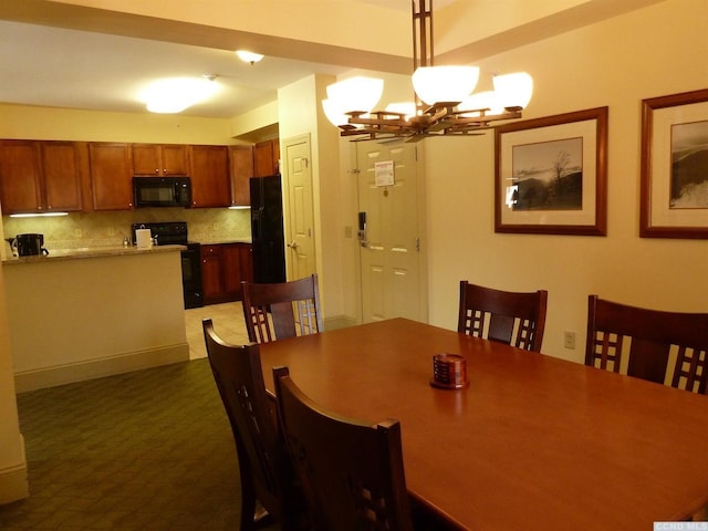 dining area featuring dark colored carpet and an inviting chandelier