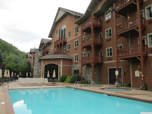 view of swimming pool featuring a hot tub