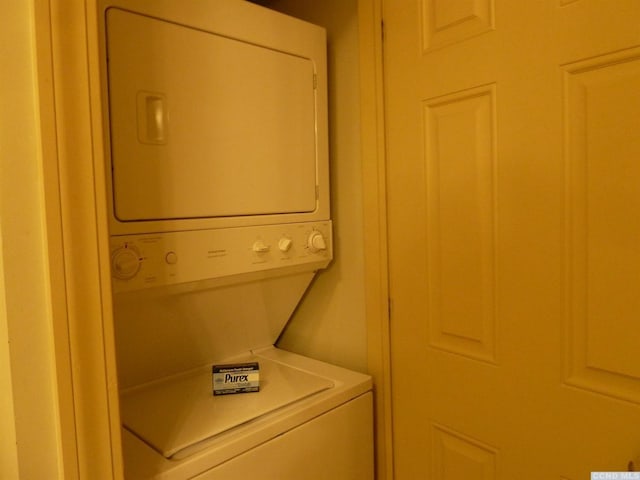 washroom featuring stacked washer / drying machine