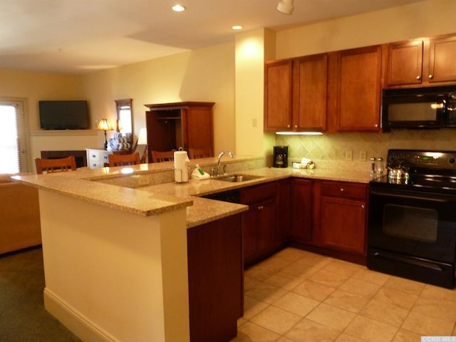 kitchen with black appliances, kitchen peninsula, and sink