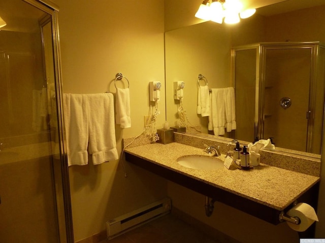 bathroom with tile patterned flooring, a baseboard radiator, a shower with door, and sink