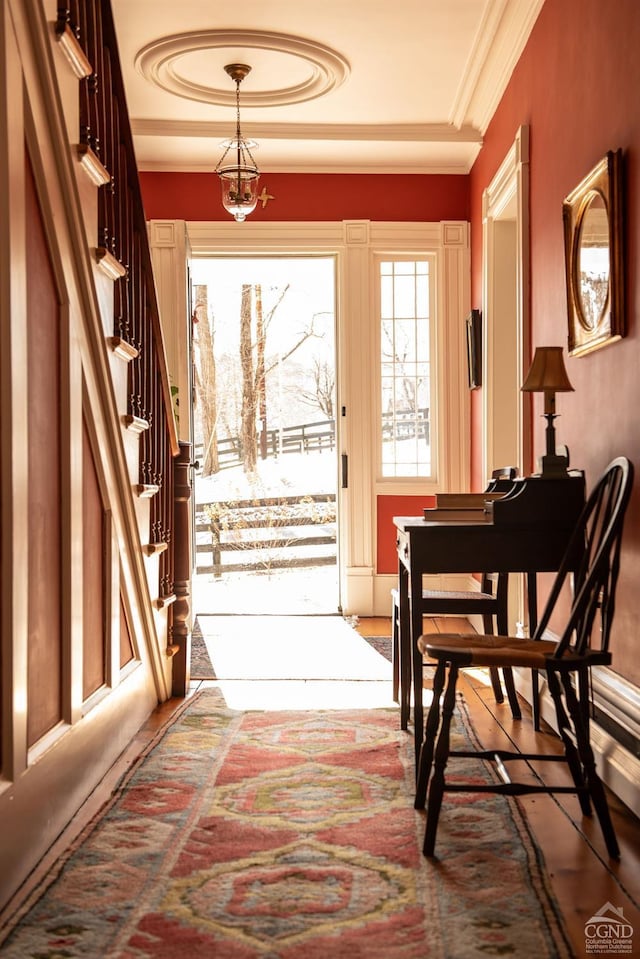 doorway featuring a notable chandelier, stairs, and ornamental molding