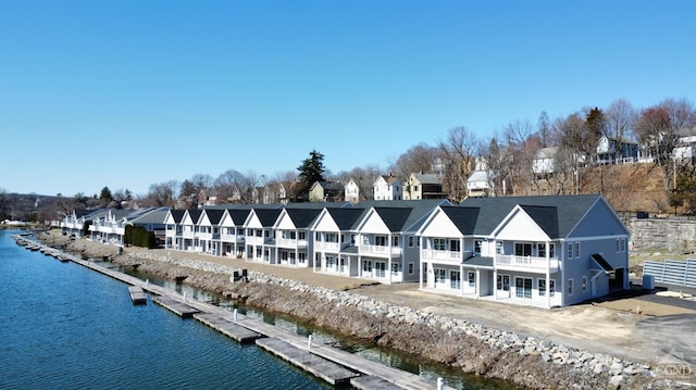 back of property featuring a water view and a residential view