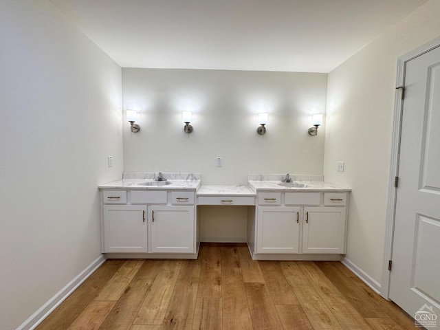 bathroom featuring baseboards, vanity, and hardwood / wood-style flooring