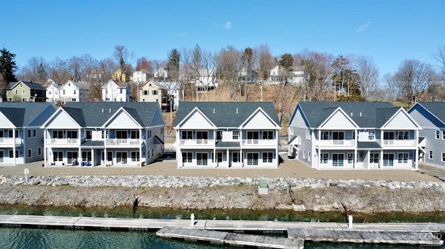 back of house with a water view and a residential view