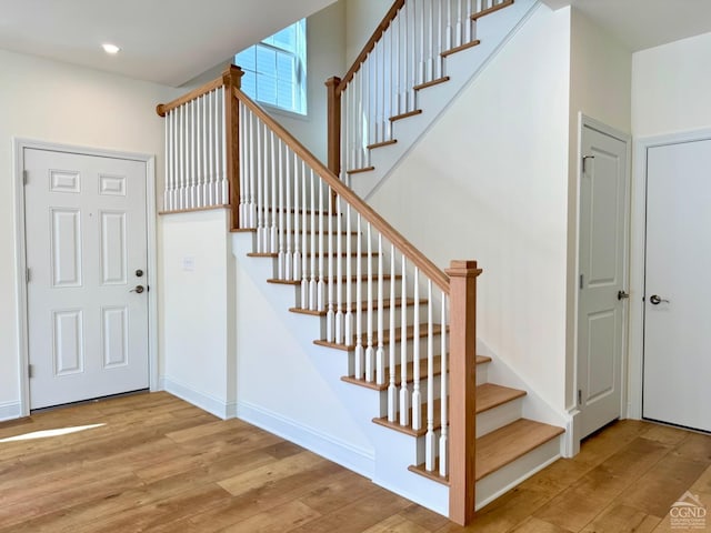 staircase featuring recessed lighting, baseboards, and wood finished floors
