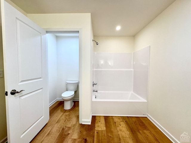 full bath with toilet, baseboards, tub / shower combination, and hardwood / wood-style floors