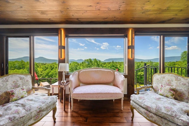 sunroom featuring a mountain view and wood ceiling