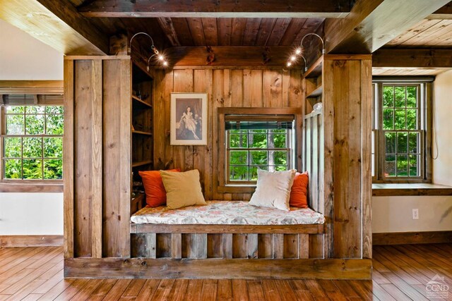 mudroom featuring beamed ceiling, wood walls, wood-type flooring, and wooden ceiling