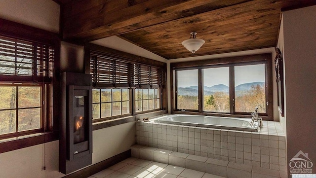 bathroom featuring a mountain view, tile patterned flooring, a wealth of natural light, and lofted ceiling