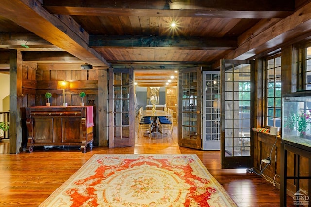 sitting room with hardwood / wood-style floors, beam ceiling, wood ceiling, and french doors