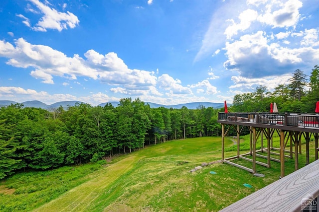 view of yard with a deck with mountain view