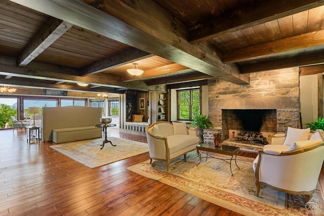 living room with hardwood / wood-style flooring, a stone fireplace, wood ceiling, and beamed ceiling