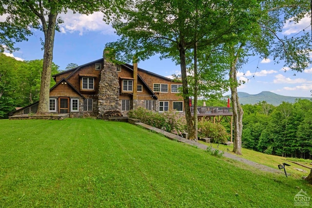 rear view of property featuring a mountain view and a yard