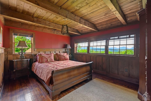 bedroom featuring beam ceiling, wood ceiling, dark wood-type flooring, and multiple windows