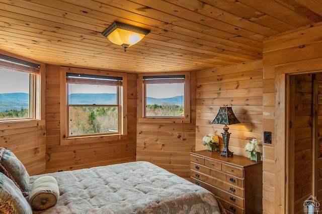 bedroom with a mountain view, wood ceiling, and wood walls