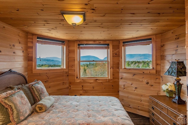 bedroom with a mountain view, wood-type flooring, and wooden ceiling