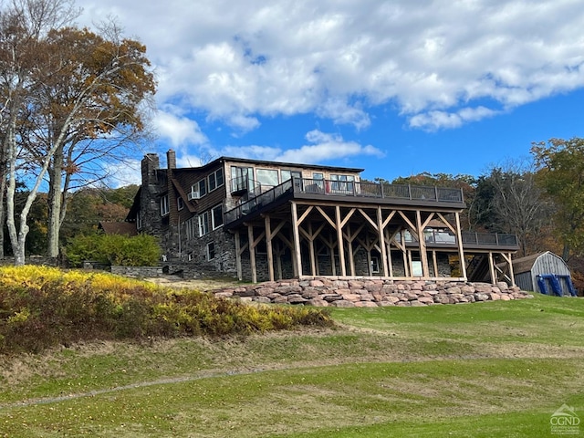 rear view of property featuring a shed and a yard