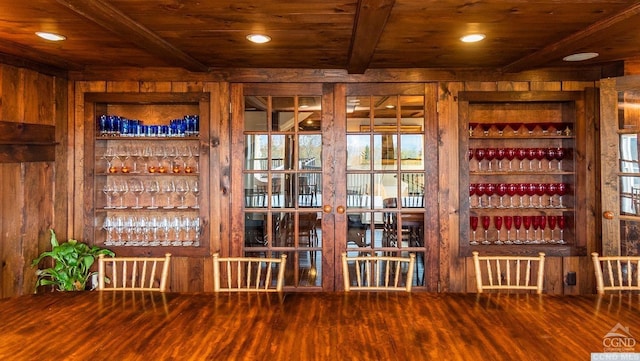 wine area with beam ceiling, wooden ceiling, wooden walls, and wood-type flooring