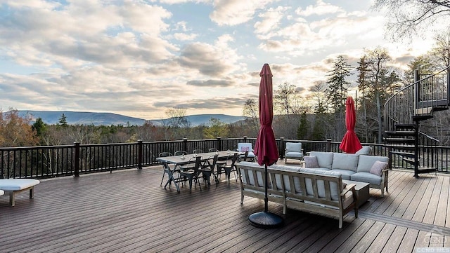 deck at dusk featuring an outdoor living space and a mountain view