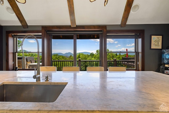 interior space featuring beamed ceiling and a mountain view