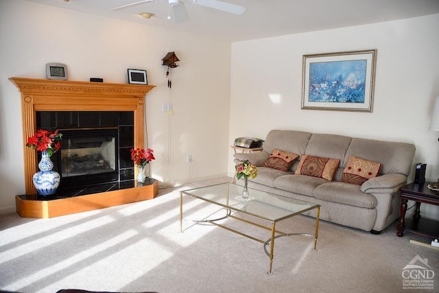 carpeted living room with ceiling fan and a tiled fireplace