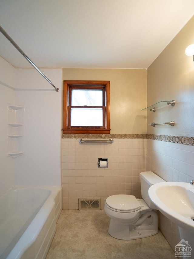 bathroom featuring toilet and tile walls