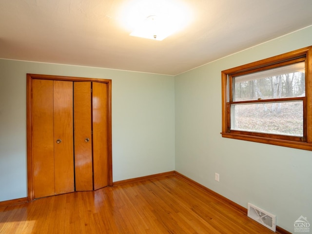 unfurnished bedroom featuring light wood-type flooring and a closet