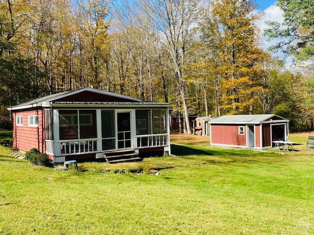 back of property with a lawn and a storage shed