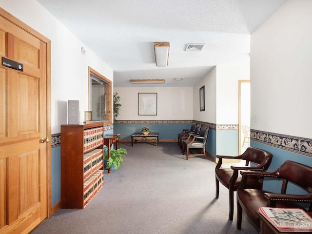 living area with carpet flooring and a textured ceiling