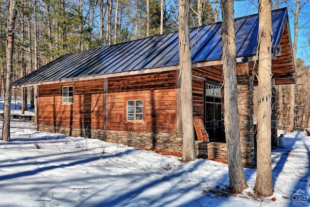 view of snow covered exterior with metal roof and a standing seam roof