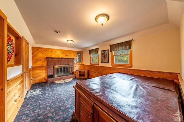 interior space with wooden walls and a brick fireplace