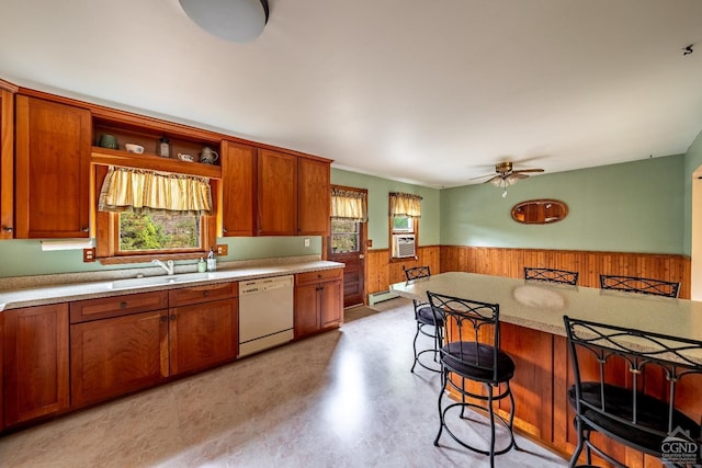 kitchen with a kitchen bar, white dishwasher, ceiling fan, and a healthy amount of sunlight