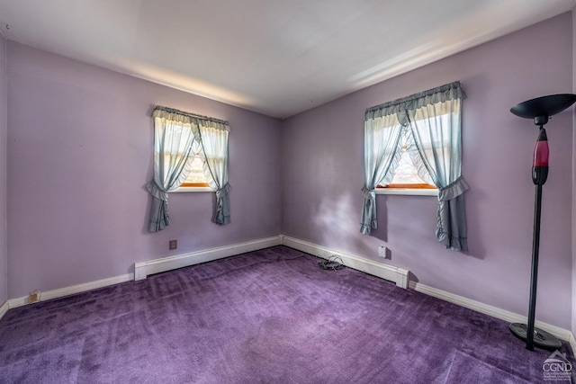 empty room featuring dark carpet and plenty of natural light