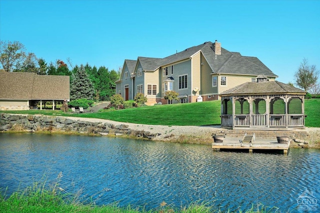 dock area with a gazebo, a lawn, and a water view