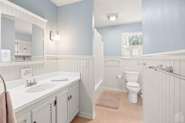 bathroom with shower / bath combo, a wainscoted wall, toilet, ornamental molding, and vanity