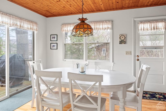 dining space featuring crown molding, wooden ceiling, and wood finished floors