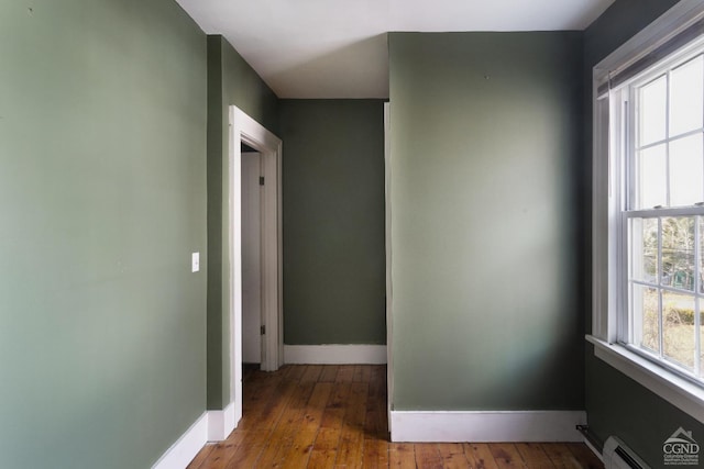 hall featuring a baseboard heating unit and dark hardwood / wood-style floors