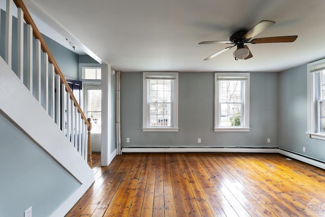 interior space featuring a baseboard heating unit, baseboards, stairway, and hardwood / wood-style floors