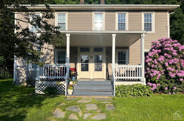 view of front of house with covered porch and a front yard