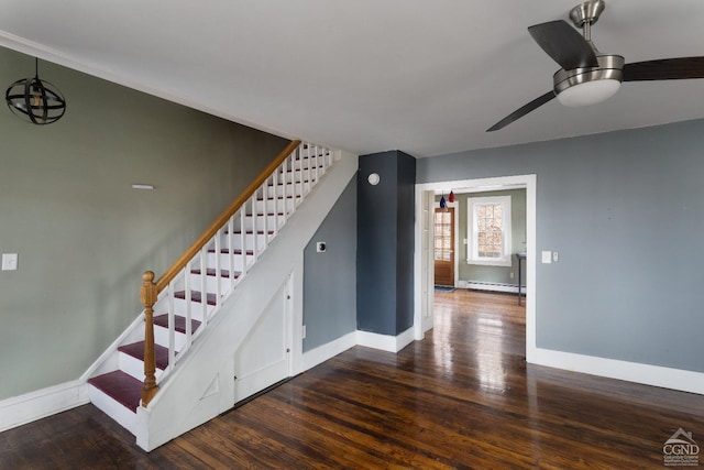 staircase featuring baseboards, a baseboard heating unit, and wood finished floors