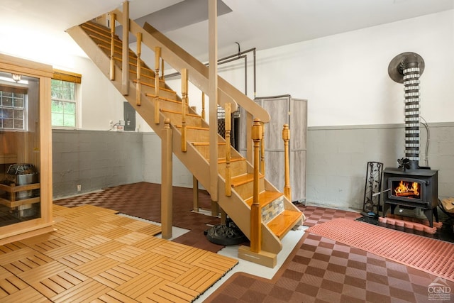 basement featuring electric panel and a wood stove