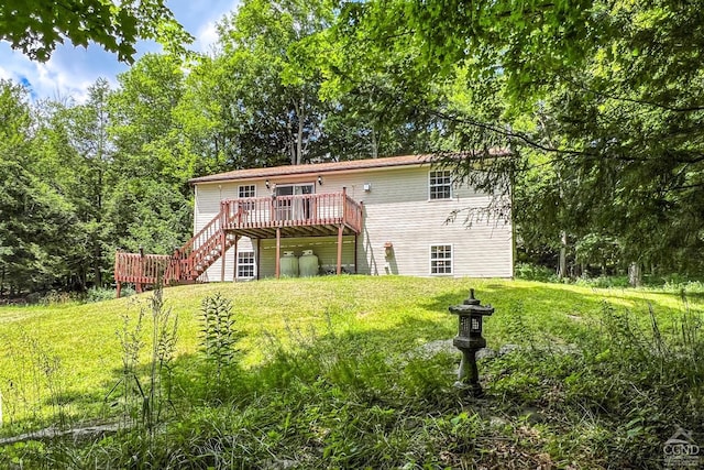 rear view of property featuring a lawn and a wooden deck