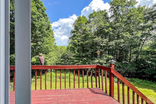 wooden deck featuring a lawn